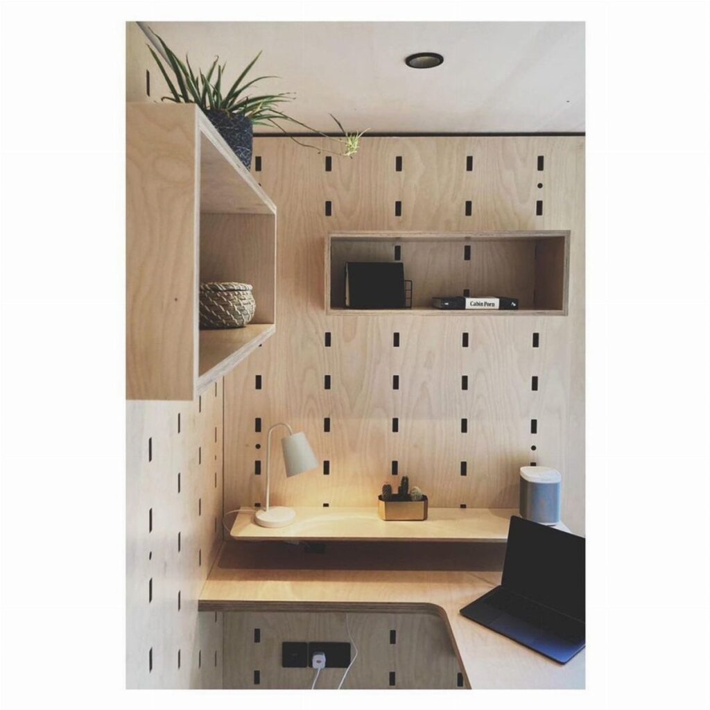 Light plywood walls with vertical slots and built-in wooden shelving in a modern interior.