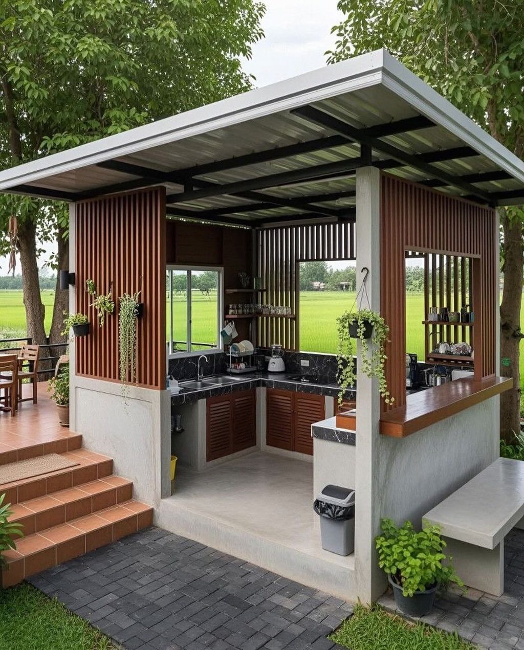 A modern outdoor kitchen structure with wooden slats, concrete counters, and built-in cabinets under a metal roof.