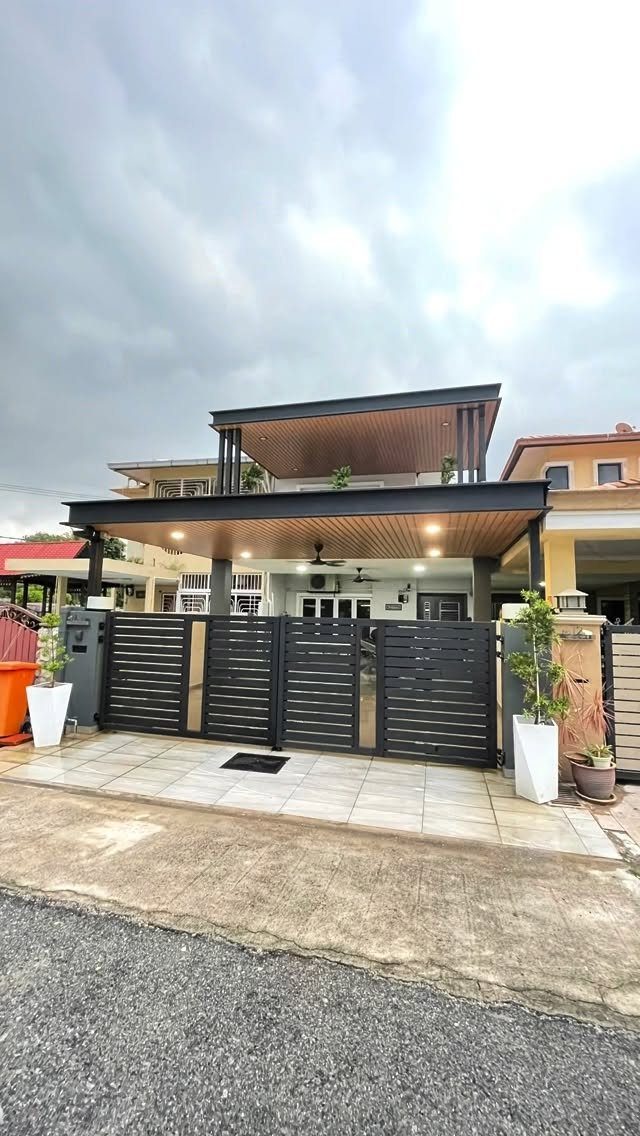 Modern black flat carport roof structure covering a paved driveway and gated entrance of a house.