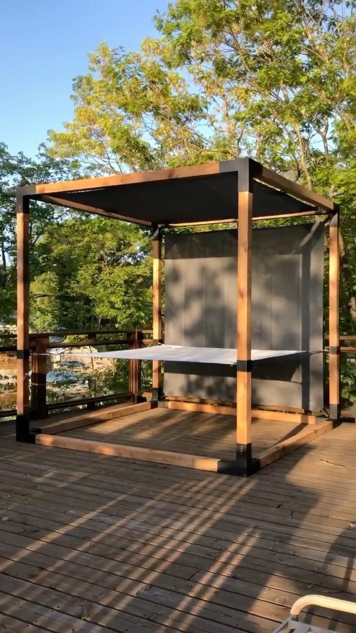 12 Deck with Gazebo Ideas for Outdoor Dining and Relaxation 8 A wooden gazebo with a white hammock hanging inside on a wooden deck.