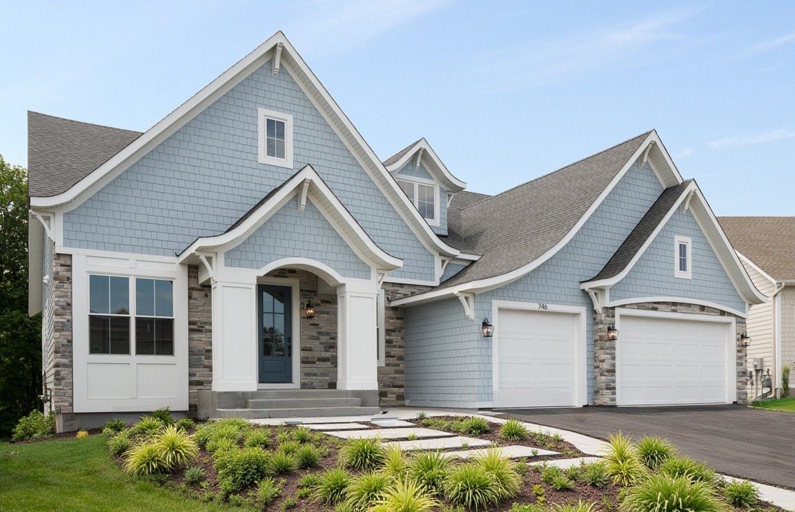 A house with light blue shake siding, white trim, and grey stone veneer accents.