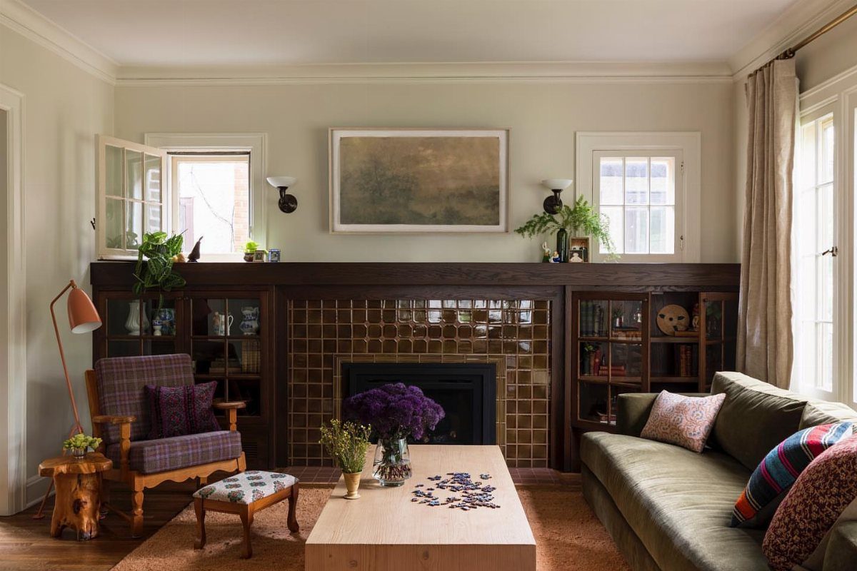 A living room with a dark wood built-in fireplace, modern coffee table, and various sofas.