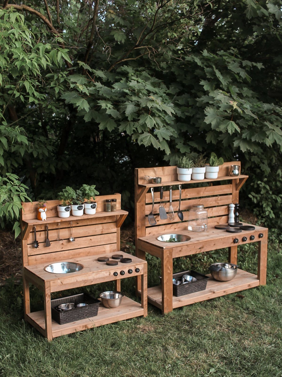 10 Wooden Garden Kitchen Ideas for Warm Outdoor Cooking 9 Two small wooden outdoor kitchen units with metal basins and utensils on green grass.