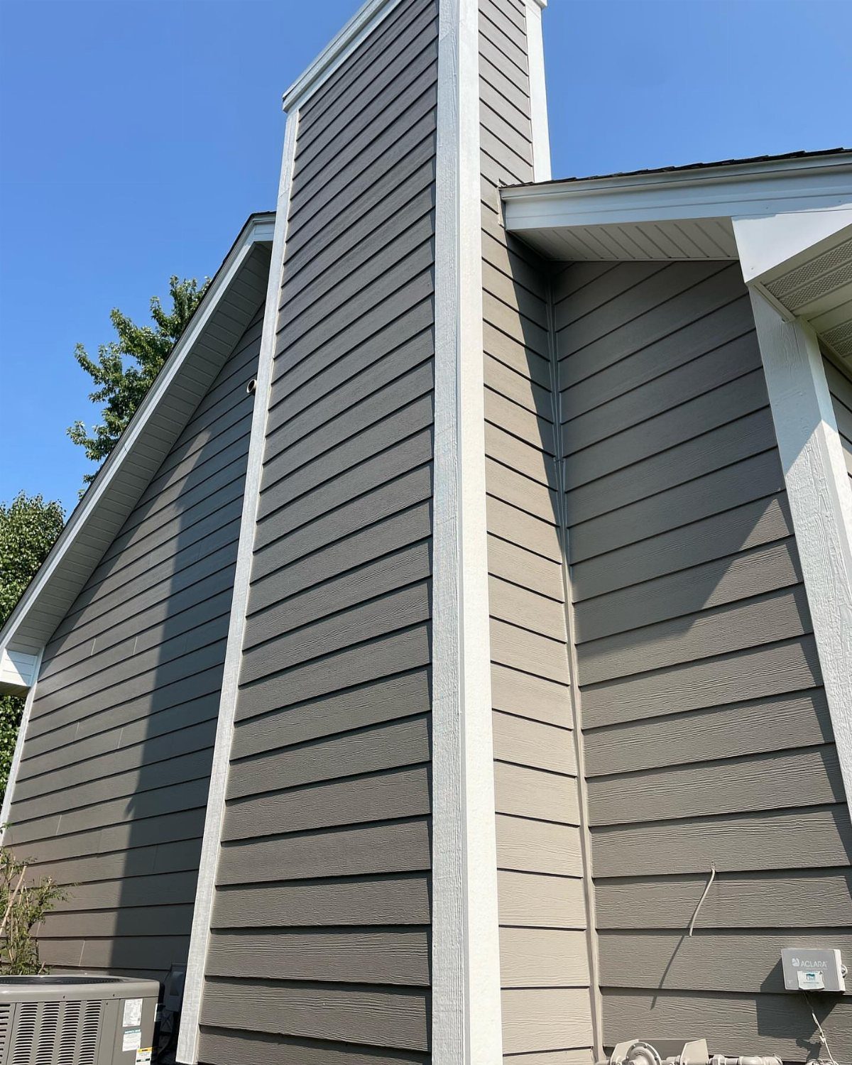 12 Trending House Colors for Exterior Looks in 2026 11 Taupe horizontal siding with white trim on a house exterior under a blue sky.